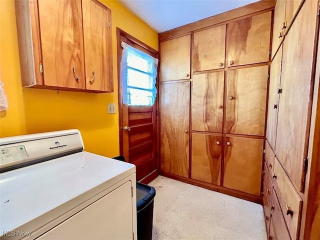 laundry room featuring cabinets and washer / dryer