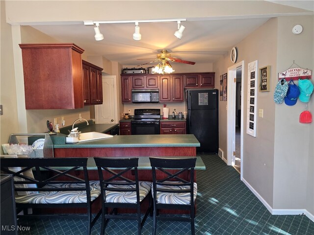 kitchen with black appliances, track lighting, sink, kitchen peninsula, and ceiling fan