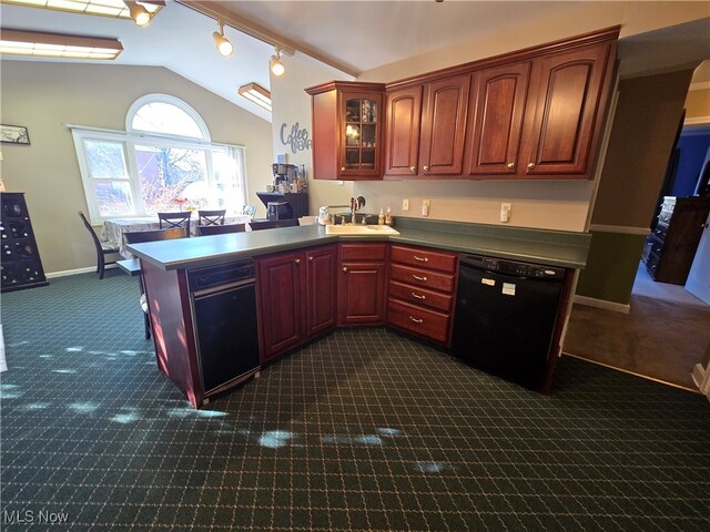 kitchen with lofted ceiling, dishwasher, kitchen peninsula, sink, and rail lighting