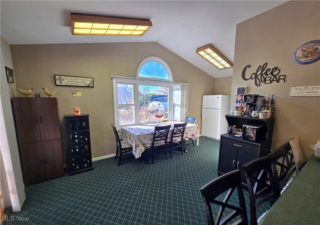 carpeted dining space with vaulted ceiling