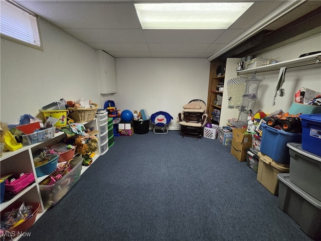 basement with a paneled ceiling and carpet floors