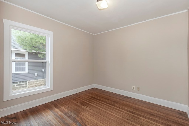 empty room with ornamental molding and hardwood / wood-style flooring