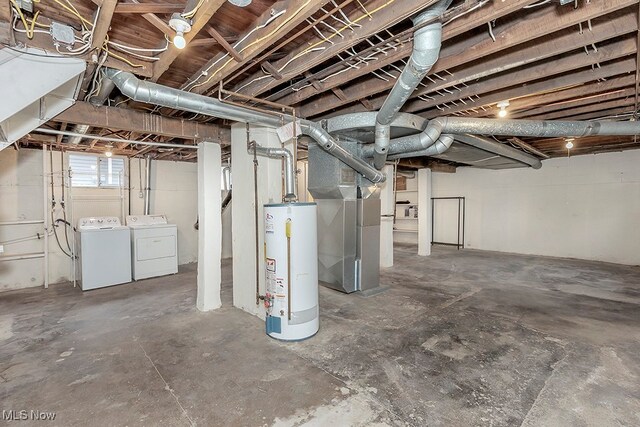 basement with washing machine and clothes dryer, gas water heater, and heating unit