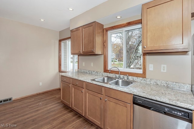 kitchen with stainless steel dishwasher, hardwood / wood-style flooring, and sink