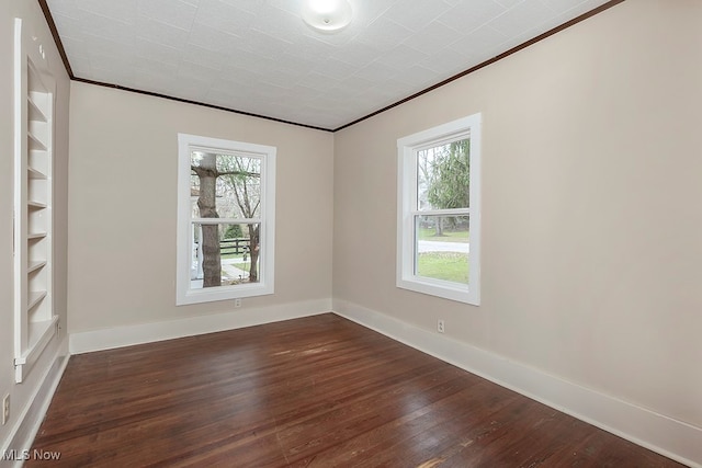 unfurnished room with dark wood-type flooring, ornamental molding, and plenty of natural light