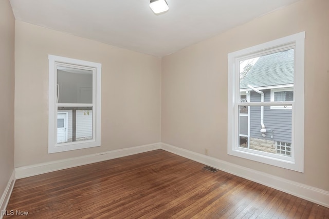 spare room featuring dark wood-type flooring