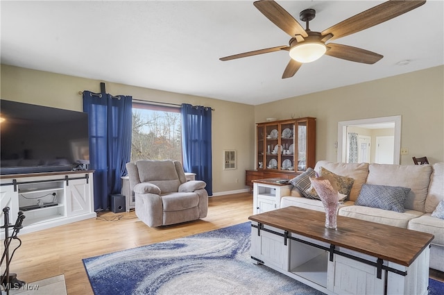 living room featuring light hardwood / wood-style floors and ceiling fan