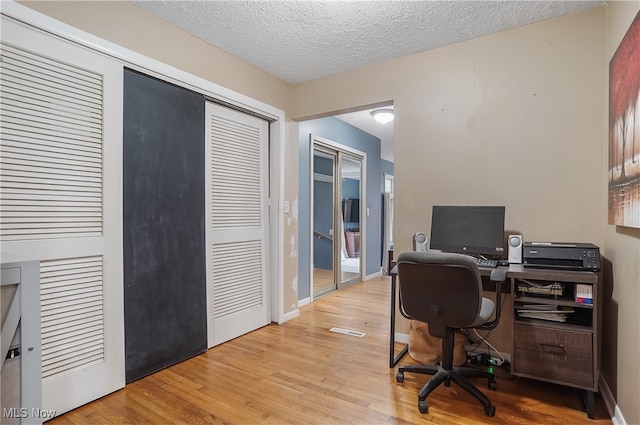 office space with a textured ceiling and light wood-type flooring