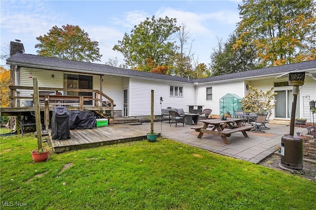 back of property featuring a patio, a lawn, a fire pit, and a wooden deck