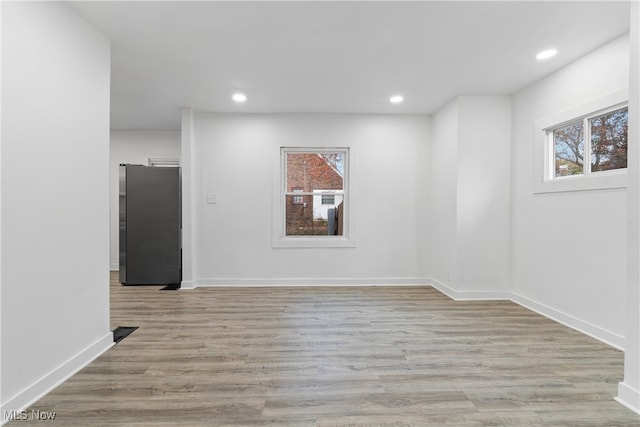 spare room featuring light hardwood / wood-style floors and a healthy amount of sunlight