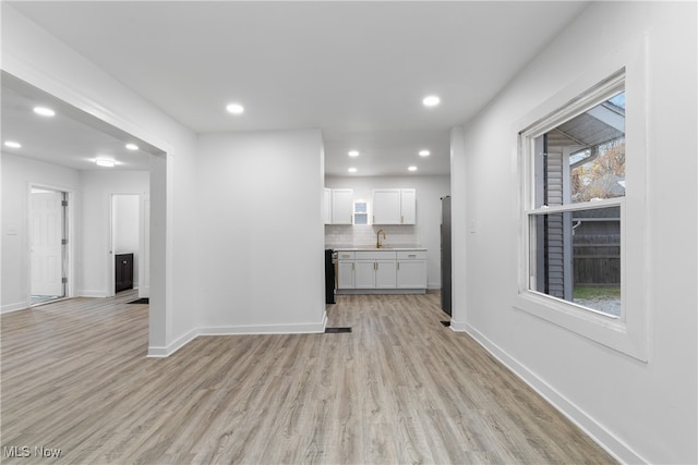 unfurnished living room with light hardwood / wood-style floors and sink