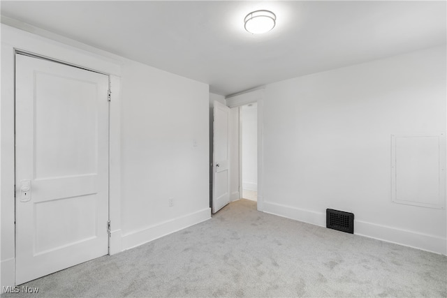 unfurnished bedroom featuring light carpet and a closet