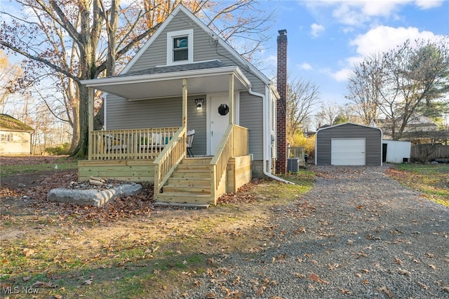 view of front of property with an outbuilding, a garage, central AC, and covered porch