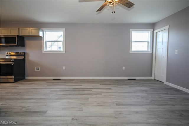 kitchen featuring light wood-type flooring, stainless steel appliances, ceiling fan, and plenty of natural light