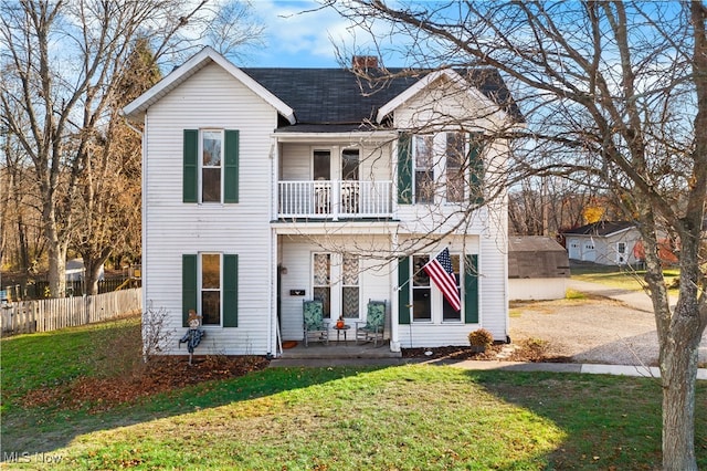 view of front of home with a balcony and a front yard