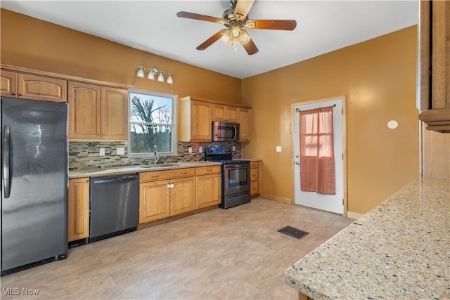 kitchen featuring sink, ceiling fan, tasteful backsplash, light stone counters, and stainless steel appliances