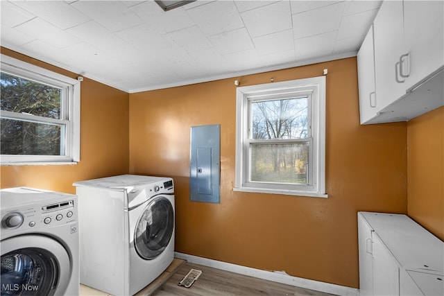 washroom featuring cabinets, electric panel, plenty of natural light, and washing machine and clothes dryer