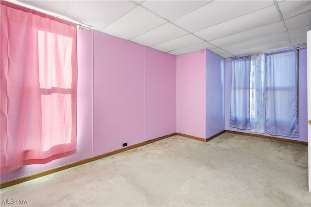 unfurnished room with a drop ceiling and light colored carpet