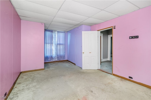 spare room featuring a drop ceiling and light colored carpet