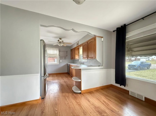 kitchen featuring appliances with stainless steel finishes, ceiling fan, light hardwood / wood-style flooring, and sink