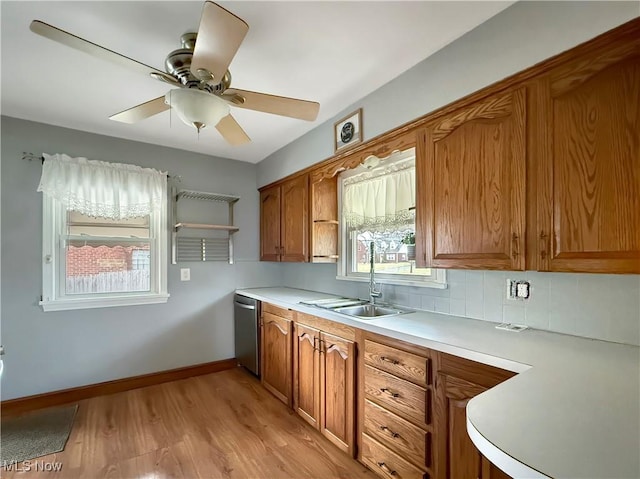 kitchen with light hardwood / wood-style flooring, sink, stainless steel dishwasher, tasteful backsplash, and ceiling fan