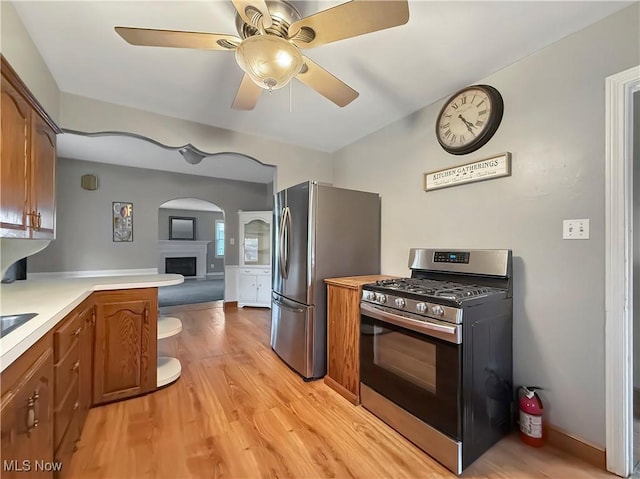 kitchen featuring ceiling fan, kitchen peninsula, stainless steel appliances, and light hardwood / wood-style floors