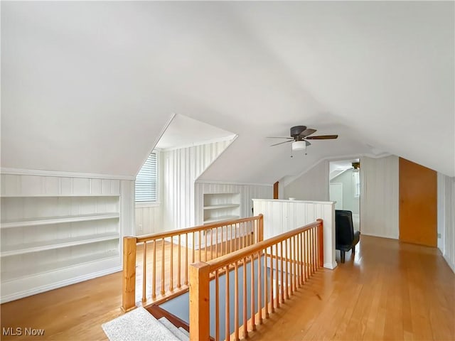 bonus room featuring lofted ceiling, built in shelves, and wood-type flooring