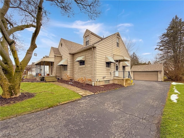 view of front of property featuring an outbuilding, a front yard, and a garage