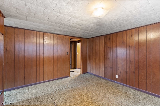 carpeted empty room featuring wooden walls