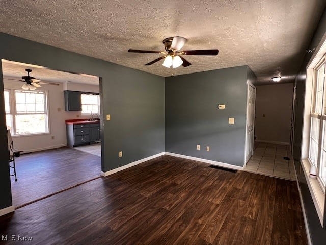 spare room with ceiling fan, a textured ceiling, sink, and dark hardwood / wood-style flooring