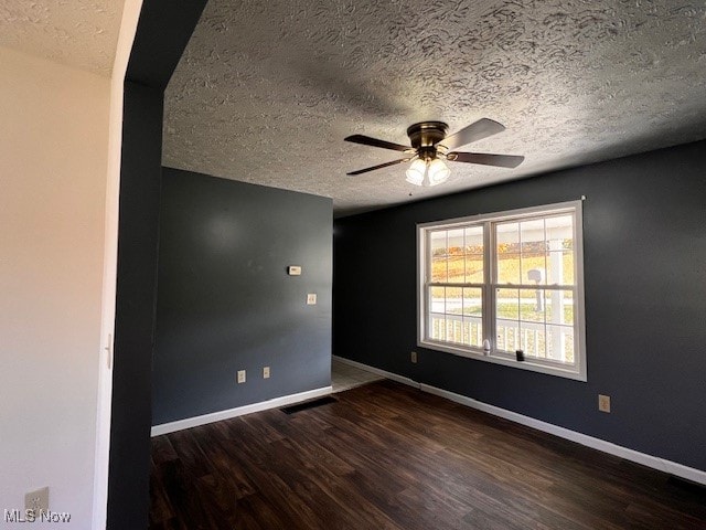 spare room with ceiling fan, dark hardwood / wood-style floors, and a textured ceiling