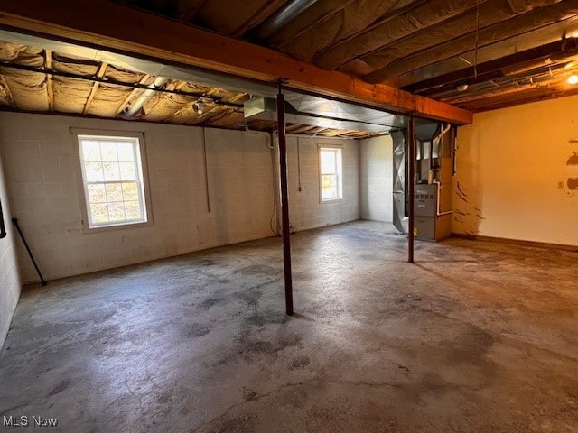 basement featuring plenty of natural light and heating unit