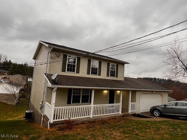 view of front of house featuring a garage, covered porch, and a front yard