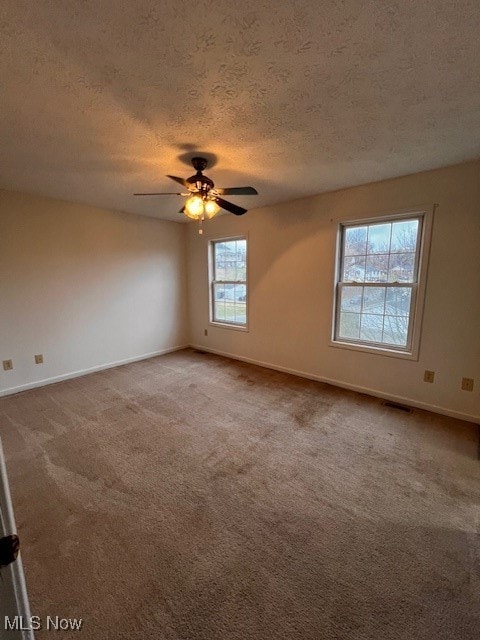 spare room with carpet floors, a textured ceiling, and ceiling fan