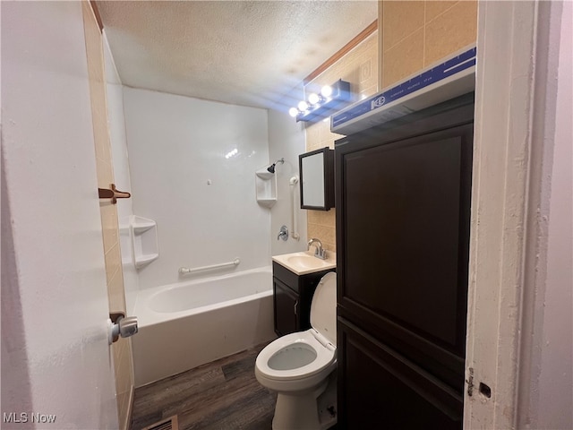 full bathroom featuring toilet, a textured ceiling, hardwood / wood-style flooring, tasteful backsplash, and vanity