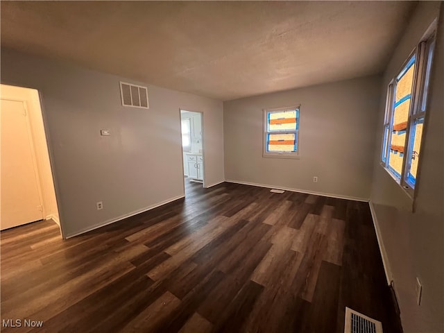 empty room with dark hardwood / wood-style flooring