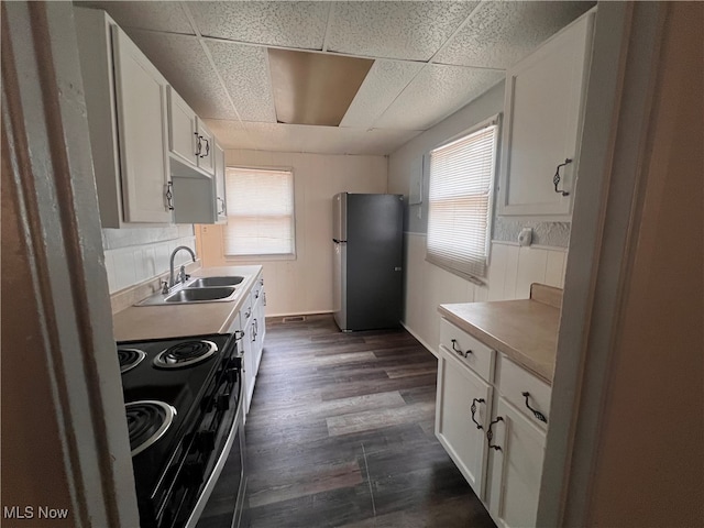 kitchen with stainless steel appliances, white cabinetry, sink, a paneled ceiling, and dark wood-type flooring