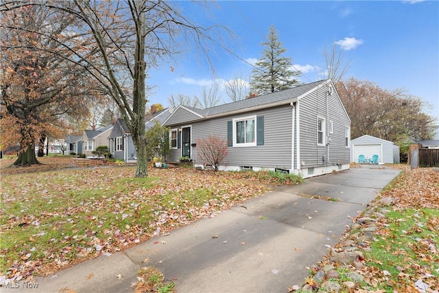 view of front of house featuring an outbuilding, a garage, and a front lawn