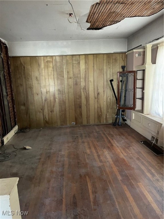 basement with dark wood-type flooring and wood walls