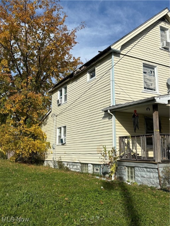 view of side of home with cooling unit and a yard