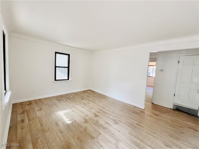 empty room featuring light wood-type flooring and a healthy amount of sunlight