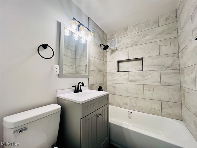 full bathroom featuring toilet, tiled shower / bath combo, and vanity