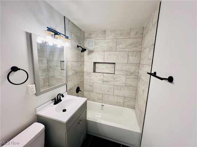 full bathroom with toilet, vanity, and tiled shower / bath