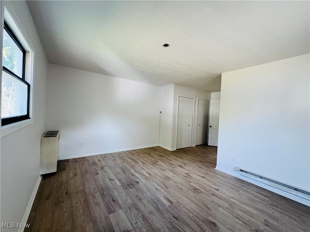 spare room with light wood-type flooring and a baseboard radiator