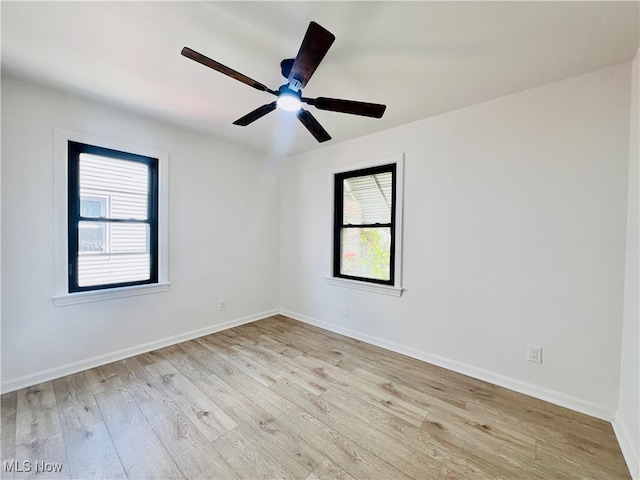 spare room featuring light hardwood / wood-style floors, ceiling fan, and a healthy amount of sunlight