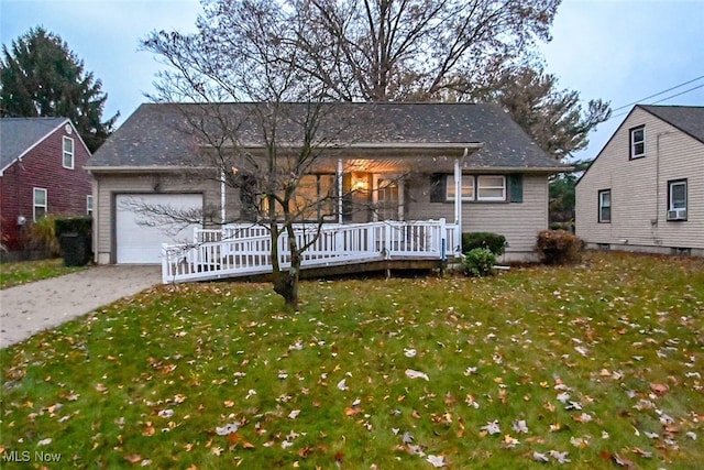 ranch-style home featuring a garage and a front lawn