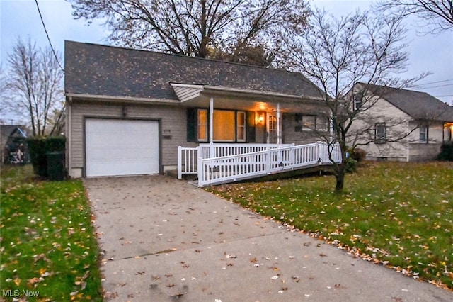 ranch-style house with a garage, a porch, and a front yard