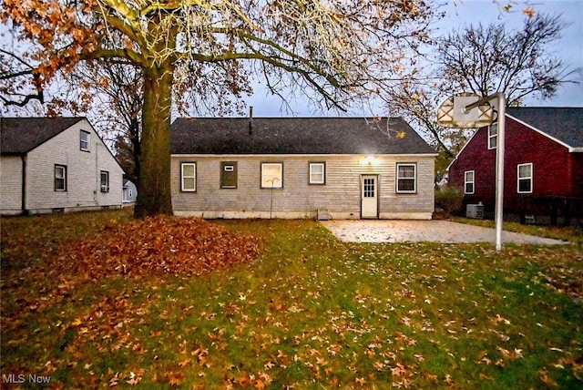 rear view of property featuring a lawn, central AC, and a patio