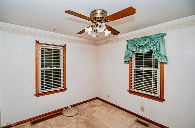 unfurnished room with ornamental molding, light carpet, and ceiling fan