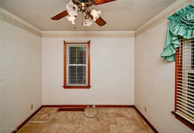 carpeted spare room with ceiling fan and crown molding